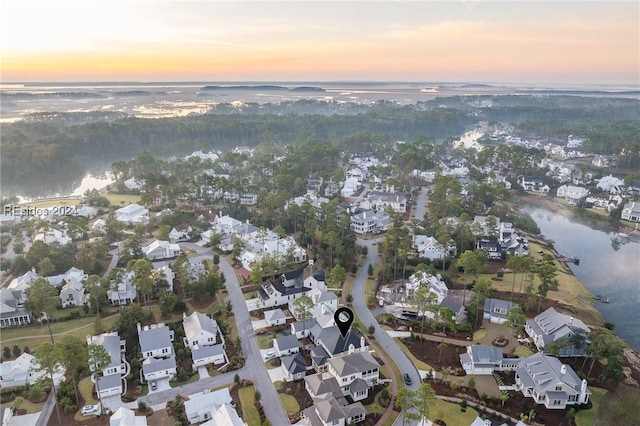 aerial view at dusk featuring a water view