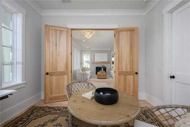 dining space featuring crown molding and a large fireplace