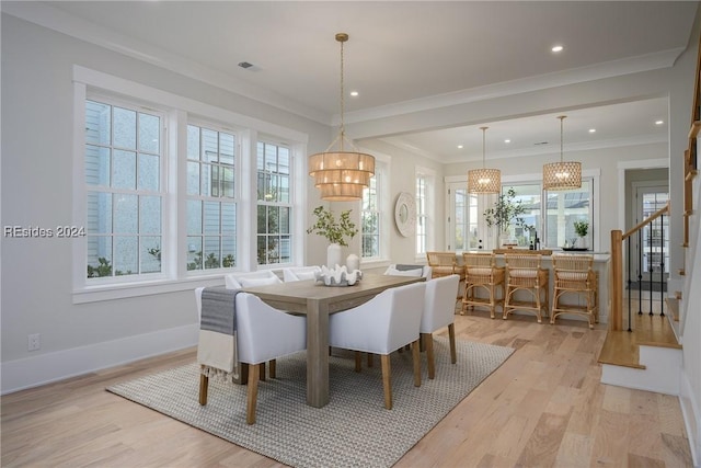 dining area with crown molding and light wood-type flooring