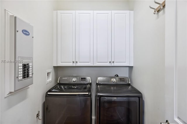 laundry room with cabinets, electric panel, and washing machine and dryer