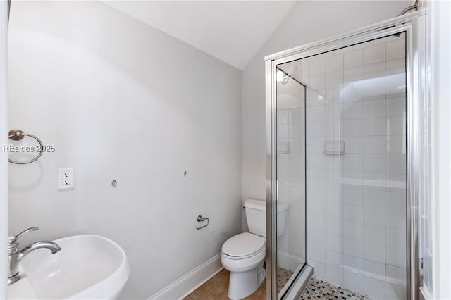 bathroom featuring an enclosed shower, sink, vaulted ceiling, and toilet