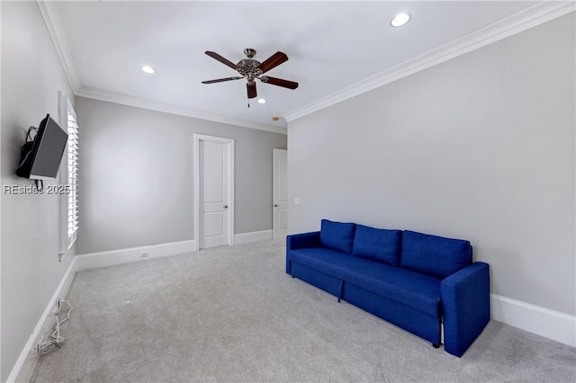 living area with ornamental molding, light colored carpet, and ceiling fan