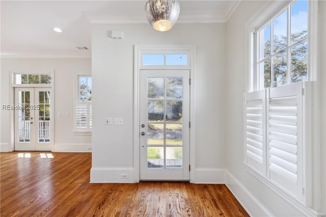 doorway featuring wood-type flooring, ornamental molding, and french doors