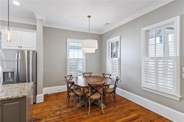 dining room with crown molding and dark hardwood / wood-style floors