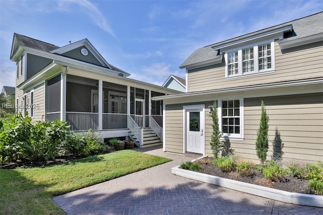 view of front of house featuring a front yard and a sunroom