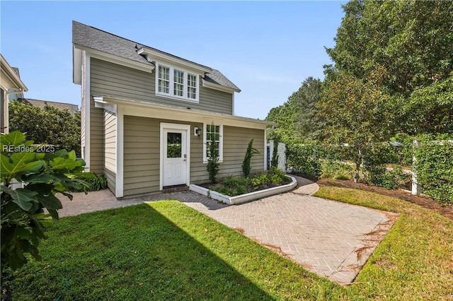 back of property with a lawn and a patio area