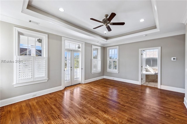 empty room featuring french doors, plenty of natural light, and a tray ceiling