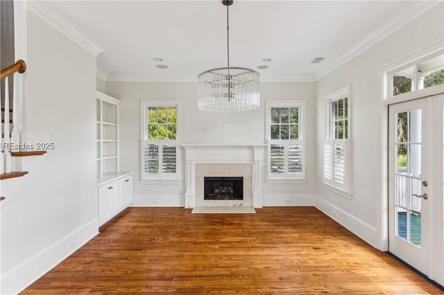 unfurnished living room with crown molding, a healthy amount of sunlight, and french doors