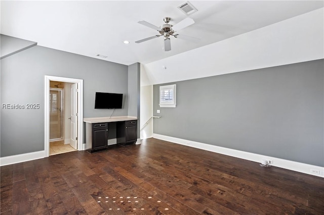 unfurnished living room featuring vaulted ceiling, dark hardwood / wood-style floors, and ceiling fan