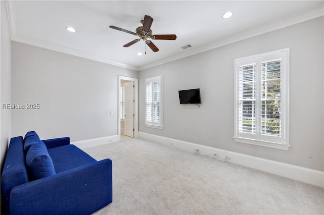 living area with crown molding, light colored carpet, and ceiling fan