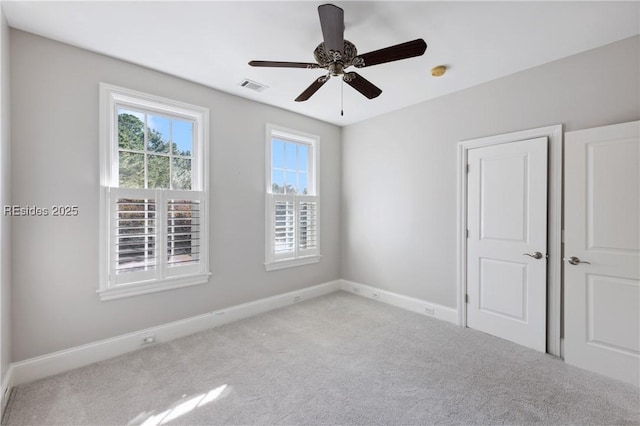 carpeted spare room featuring ceiling fan