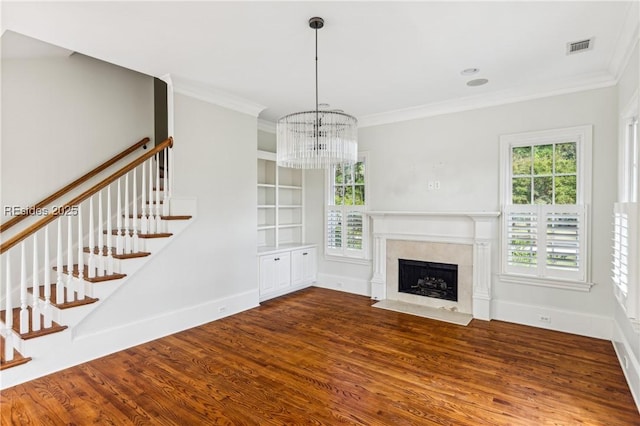 unfurnished living room with ornamental molding, dark hardwood / wood-style flooring, and a notable chandelier