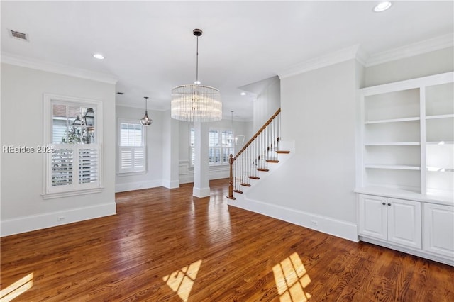 foyer entrance featuring crown molding, dark wood-type flooring, and a chandelier