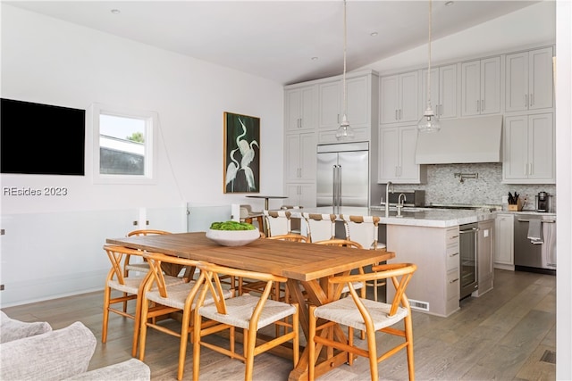 dining area featuring wine cooler, sink, and light hardwood / wood-style flooring