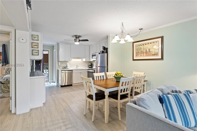 dining area featuring crown molding, a textured ceiling, and light wood-type flooring