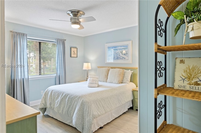 bedroom featuring crown molding, light hardwood / wood-style flooring, a textured ceiling, and ceiling fan