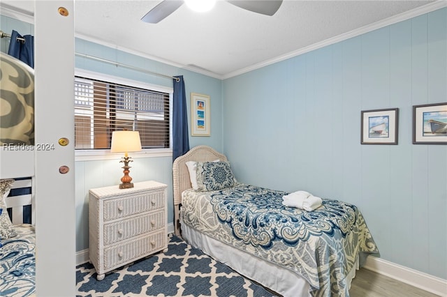 bedroom with ceiling fan, ornamental molding, and wood-type flooring