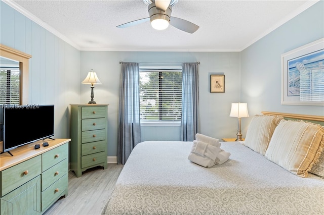 bedroom with ceiling fan, ornamental molding, a textured ceiling, and light hardwood / wood-style flooring