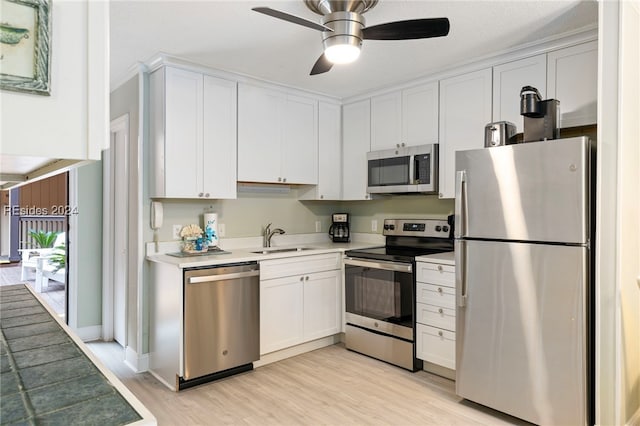 kitchen with sink, white cabinetry, light hardwood / wood-style flooring, ceiling fan, and stainless steel appliances