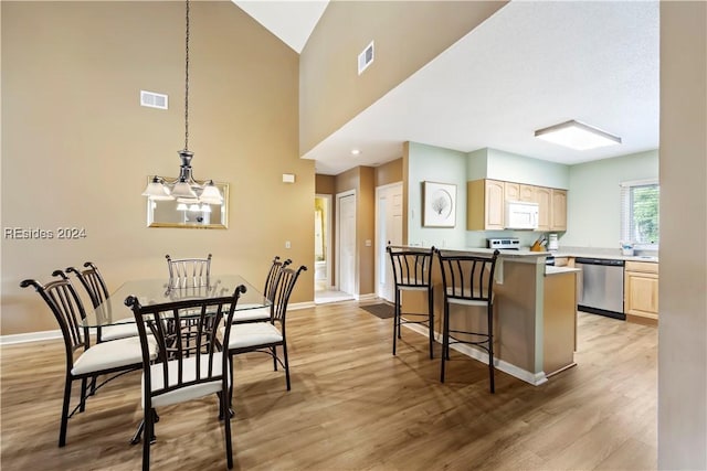 dining space featuring light hardwood / wood-style flooring and a chandelier