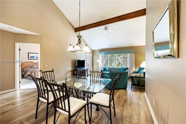 dining room featuring lofted ceiling with beams, a notable chandelier, and light hardwood / wood-style floors