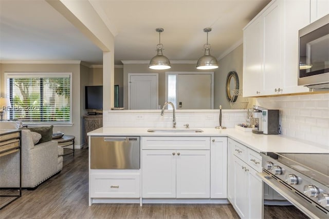 kitchen featuring pendant lighting, sink, appliances with stainless steel finishes, white cabinetry, and tasteful backsplash