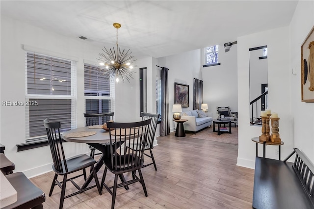 dining space featuring hardwood / wood-style flooring and a chandelier