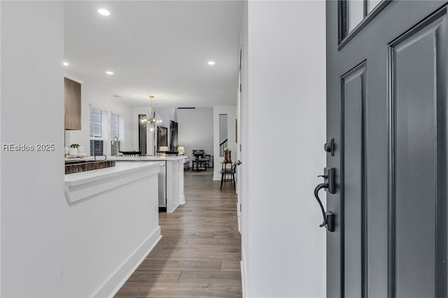 foyer with light hardwood / wood-style floors and a notable chandelier