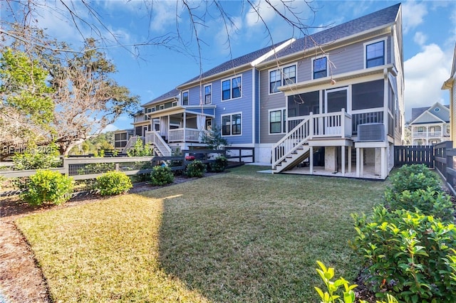 back of property with a lawn, a sunroom, and a patio area