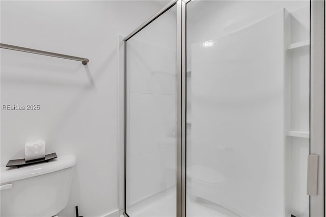 bathroom featuring walk in shower and toilet