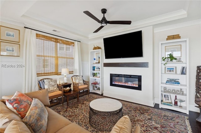 living room featuring crown molding, ceiling fan, and a tray ceiling