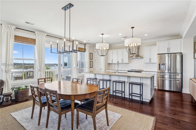 dining room featuring sink, ornamental molding, and dark hardwood / wood-style floors