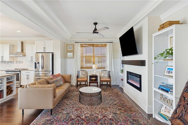 living room featuring dark hardwood / wood-style flooring, ornamental molding, and ceiling fan