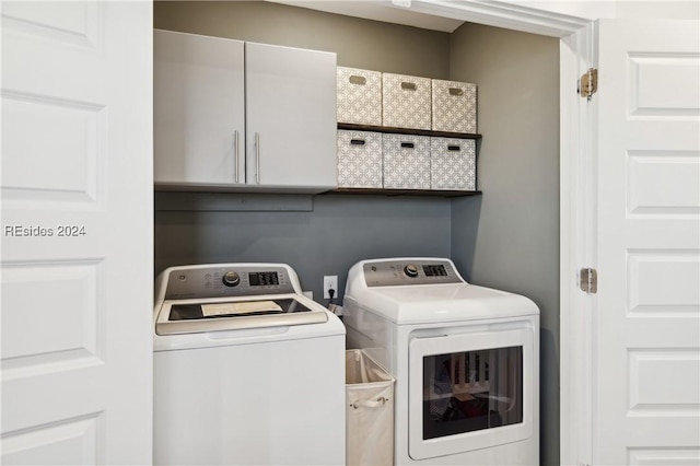 laundry area with washing machine and dryer and cabinets