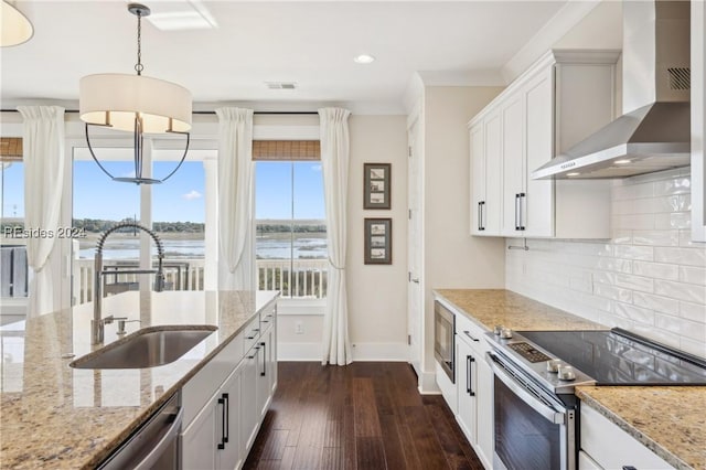 kitchen with wall chimney range hood, sink, white cabinets, and appliances with stainless steel finishes