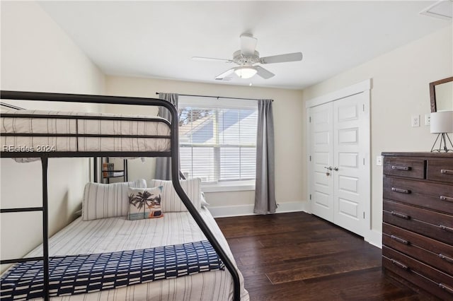 bedroom with dark hardwood / wood-style floors, ceiling fan, and a closet