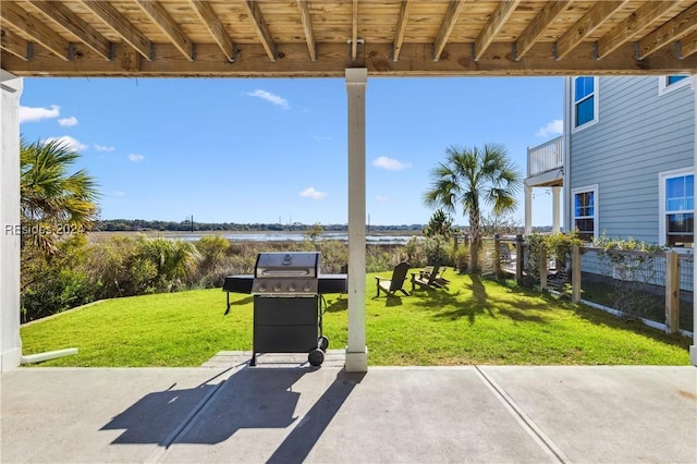 view of patio with a grill and a water view