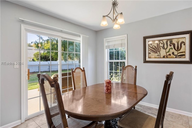 tiled dining space with a chandelier