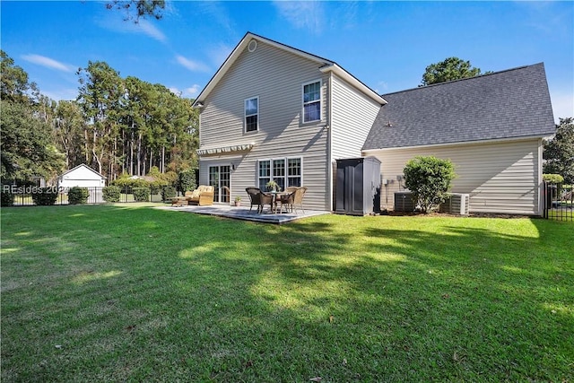 rear view of house with central AC, a patio area, and a lawn