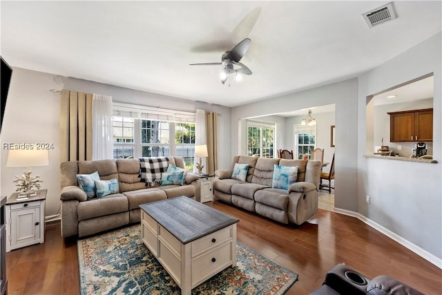 living room with ceiling fan, plenty of natural light, and dark hardwood / wood-style floors