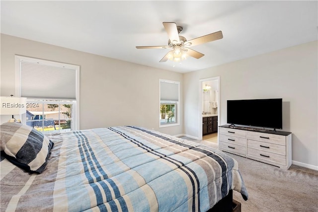 carpeted bedroom with ceiling fan and ensuite bath