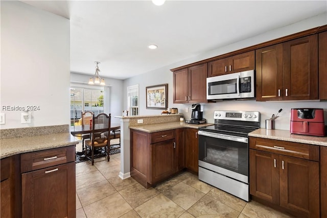 kitchen featuring light stone counters, dark brown cabinets, hanging light fixtures, appliances with stainless steel finishes, and kitchen peninsula