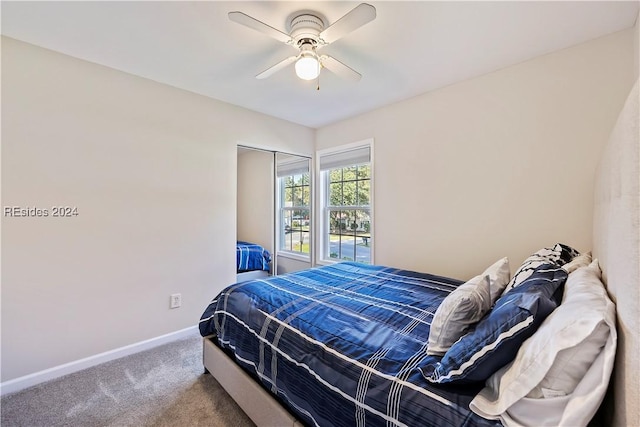 carpeted bedroom with ceiling fan and a closet