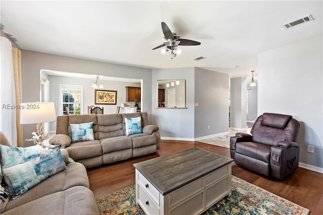 living room featuring dark wood-type flooring and ceiling fan