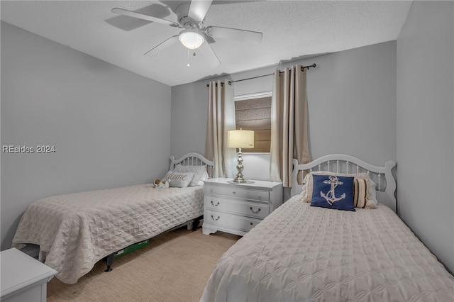 carpeted bedroom featuring ceiling fan and a textured ceiling