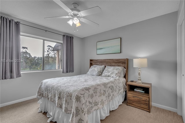 bedroom with ceiling fan and light colored carpet