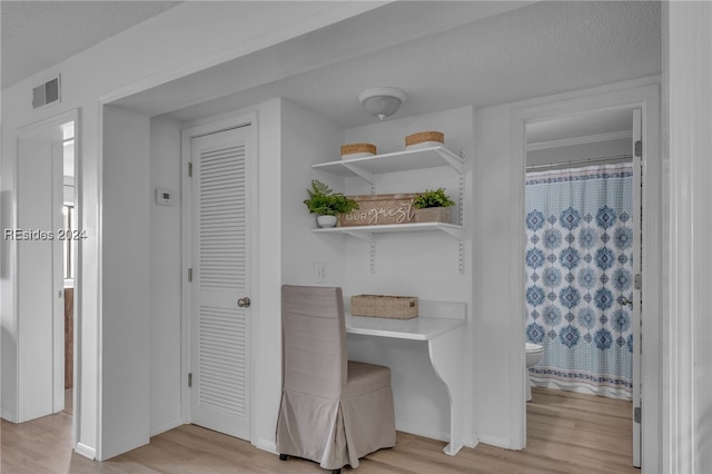 unfurnished dining area with light hardwood / wood-style floors and a textured ceiling