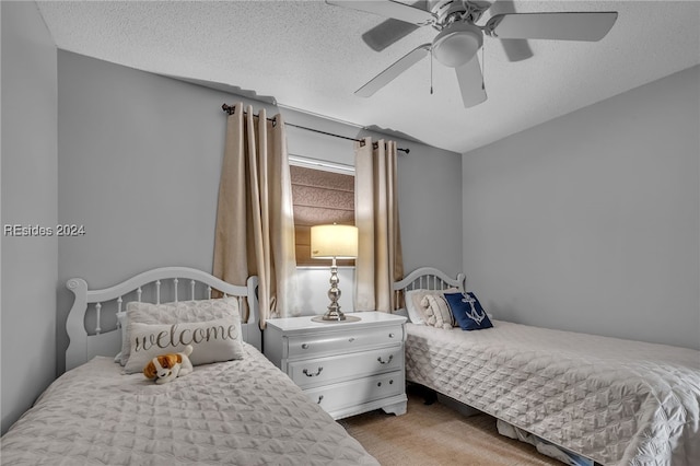 carpeted bedroom featuring ceiling fan and a textured ceiling