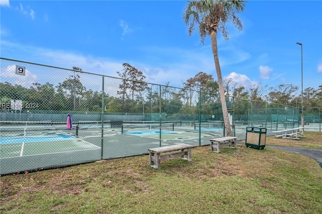 view of tennis court featuring a yard