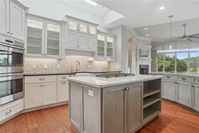 kitchen featuring hanging light fixtures, light wood-type flooring, sink, and appliances with stainless steel finishes